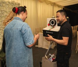 Photo booth attendant preparing the camera for guests at Meadow Tree Marquee