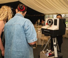 Guests using a retro photo booth inside Meadow Tree Marquee