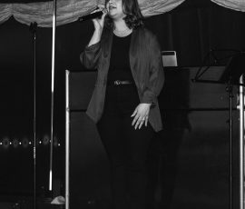 Black and white photograph of a live singer performing at Meadow Tree Marquee