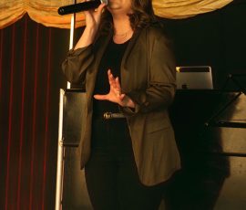 Singer performing under warm stage lighting at Meadow Tree Marquee