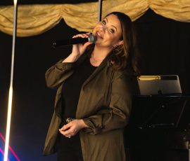 Live singer performing with a microphone at Meadow Tree Marquee